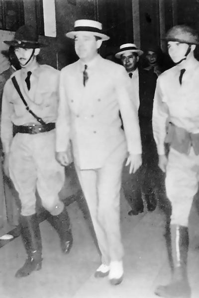 Huey Long surrounded by armed guards in the Louisiana State Capitol