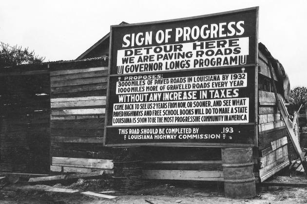 Sign promoting Huey Long's road-paving program: "3,000 miles of paved roads in Louisiana by 1932 ... without any increase in taxes."
