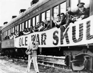 Huey Long standing in front of a train of Louisiana State University students on their way to Nashville for the LSU-Vanderbilt football game. 'Ole War Skule' is a reference to LSU's founding as a military academy after the Civil War.